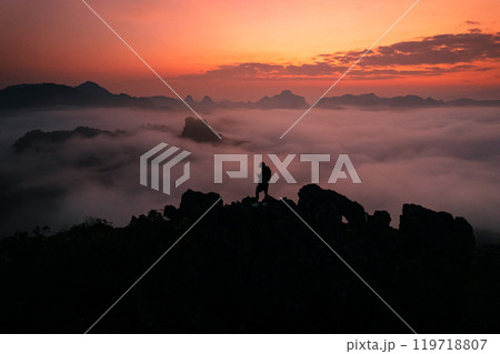 Man standing on the mountain and sea view with mountains in the early morning Man standing on the mountain and sea view with mountains in the early morning 119718807