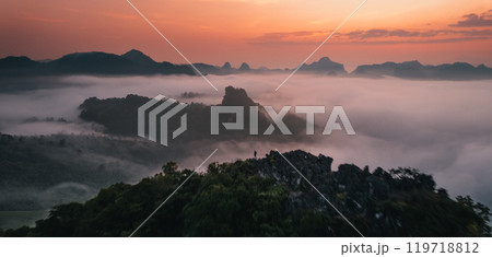 Aerial View of Morning fog and mountains as the sun rises from above 119718812