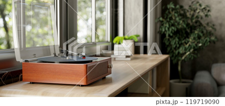 A vintage wooden record vinyl player on a wooden cabinet by the window in a contemporary living room A vintage wooden record vinyl player on a wooden cabinet by the window in a contemporary living room 119719090