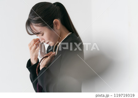 涙を流す喪服の女性 119719319