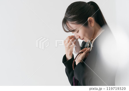 涙を流す喪服の女性 119719320