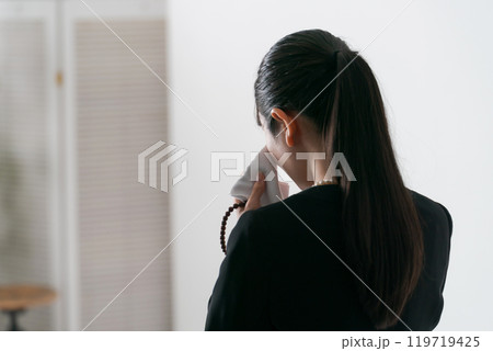 涙を流す喪服の女性の後ろ姿 涙を流す喪服の女性の後ろ姿 119719425