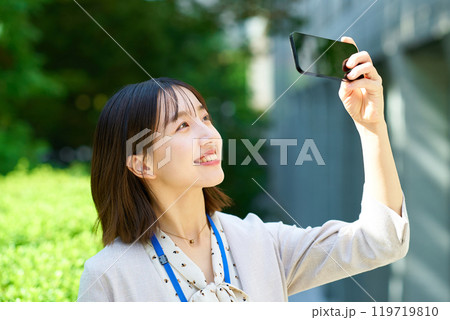 スマートフォンを掲げる若いビジネスウーマン 119719810