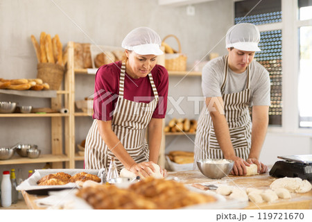 Two chefs knead dough and communicate while working Two chefs knead dough and communicate while working 119721670