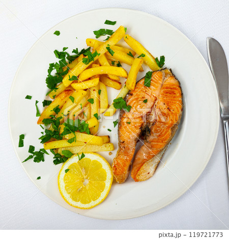 Italian dish of tasty steak of baked salmon with french fries Italian dish of tasty steak of baked salmon with french fries 119721773