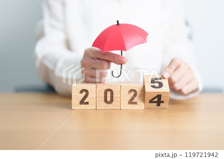 2024 end year to Happy New Year 2025 with hand holding red umbrella. Insurance, protection, safety and New year holiday Concepts 119721942