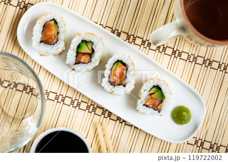 Uramaki California roll with salmon, avocado wrapped in rice with seasame. Uramaki California roll with salmon, avocado wrapped in rice with seasame. 119722002