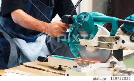 電動ノコギリを使って木材を切る男性　DIY 119722023