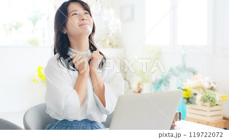 おしゃれな部屋でノートパソコンを使ってガッツポーズする女性 おしゃれな部屋でノートパソコンを使ってガッツポーズする女性 119722072