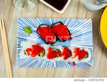 On plate with set of sushi - uramaki roll tobiko gunga with cucumber, avocado and salmon 119722452