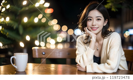 イルミネーションの美しい夜のカフェで頬杖を付くポースをする女性 イルミネーションの美しい夜のカフェで頬杖を付くポースをする女性 119723478