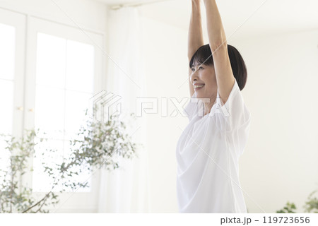 部屋で体操をするミドル女性 部屋で体操をするミドル女性 119723656