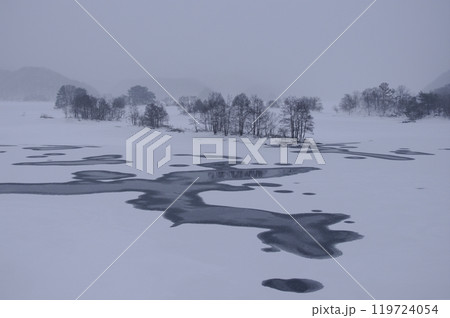 雪降る秋元湖展望台から上流の発電所から放流後湖面の氷紋5 119724054