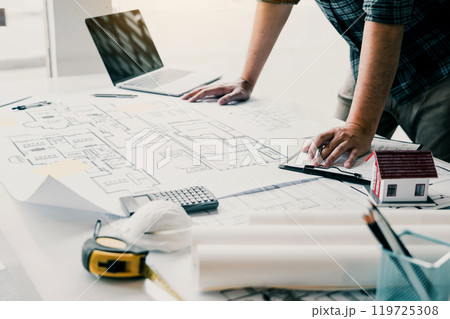 Engineers are designing working on blueprints and analyzing the structure of the project. Engineers are designing working on blueprints and analyzing the structure of the project. 119725308