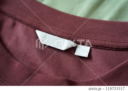 Close up of blank white clothing care label on shirt fabric background. 119725317