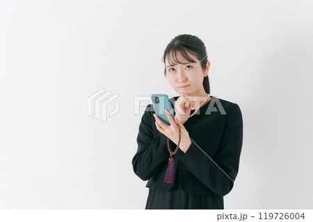 スマホを持って考える喪服の女性 119726004