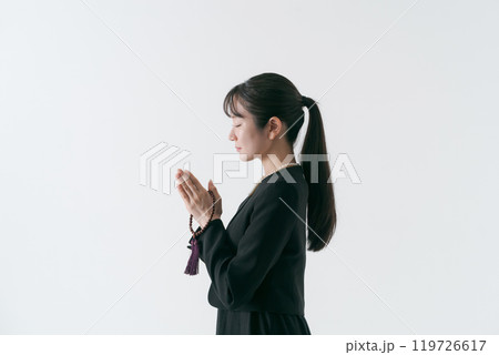 手を合わせる喪服の女性 119726617