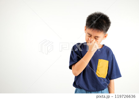Asian young child unhappy what a smell disgust expression squeezing nose with fingers. Kid boy primary have something stinks bad smell situation, studio shot isolated on white background, Healthcare Asian young child unhappy what a smell disgust expression squeezing nose with fingers. Kid boy primary have something stinks bad smell situation, studio shot isolated on white background, Healthcare 119726636