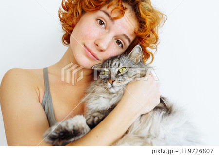 portrait red-haired teenage girl with gray fluffy cat portrait red-haired teenage girl with gray fluffy cat 119726807