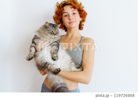 portrait red-haired teenage girl with gray fluffy cat 119726808