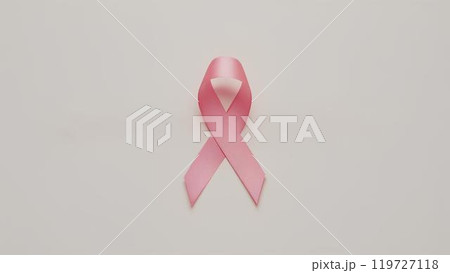 Pink ribbon on a light colored background as a symbol of support for the fight against cancer with space for text 119727118