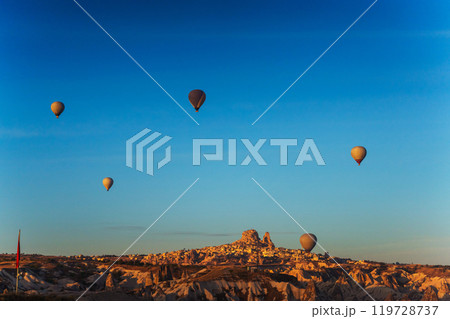 Colorful hot air balloons fly gracefully over a vibrant skyline in valley Cappadocia Turkey Colorful hot air balloons fly gracefully over a vibrant skyline in valley Cappadocia Turkey 119728737