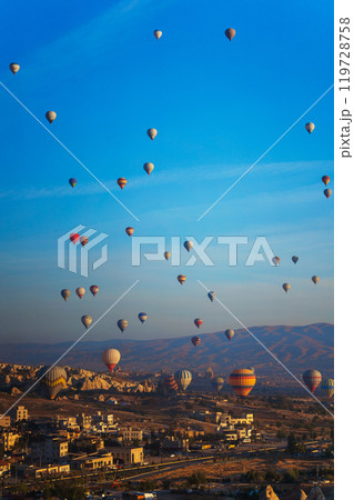 Colorful hot air balloons fly gracefully over a vibrant skyline in valley Cappadocia Turkey Colorful hot air balloons fly gracefully over a vibrant skyline in valley Cappadocia Turkey 119728758