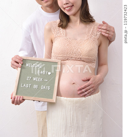 レターボードを持って若い妊婦と寄り添う夫 119732423