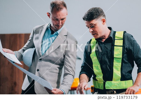 Team Engineers with draft plan of building on constructing site. Engineer work on site. engineer visit and inspection site engineer. Inspector engineer check and working on site. Team Engineers with draft plan of building on constructing site. Engineer work on site. engineer visit and inspection site engineer. Inspector engineer check and working on site. 119733179