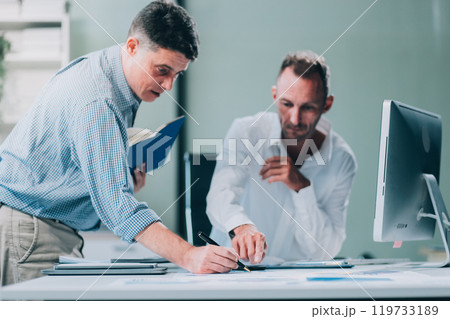 Two businessmen working together Analyze financial reports with charts and graphs while using the calculator to calculate budget, income, taxes, business growth. Startup business idea. Two businessmen working together Analyze financial reports with charts and graphs while using the calculator to calculate budget, income, taxes, business growth. Startup business idea. 119733189