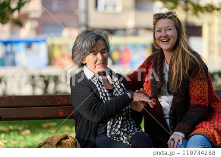 Embracing Generations: A Daughter's Love and Support for Her Senior Mother on a Sunny Day in the Park 119734288