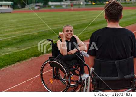 A woman with disability in a wheelchair talking with friend after training on the marathon course A woman with disability in a wheelchair talking with friend after training on the marathon course 119734638