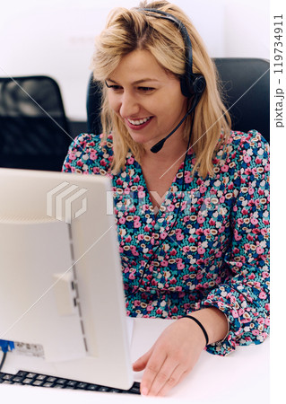 Friendly Call Center Agent Answering Incoming Calls with Headset Providing Remote Customer Service. Friendly Call Center Agent Answering Incoming Calls with Headset Providing Remote Customer Service. 119734911