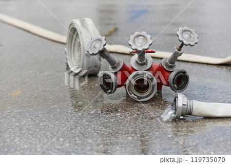 Coiled Fire Hose Ready for Action on the Ground 119735070
