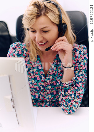 Friendly Call Center Agent Answering Incoming Calls with Headset Providing Remote Customer Service. 119735121