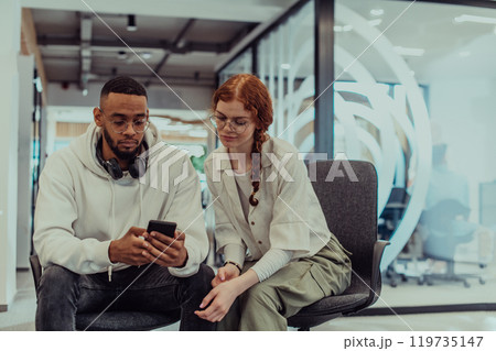 In a modern office African American young businessman and his businesswoman colleague, with her striking orange hair, engage in collaborative problem-solving sessions In a modern office African American young businessman and his businesswoman colleague, with her striking orange hair, engage in collaborative problem-solving sessions 119735147
