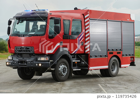 In this captivating scene, a state-of-the-art firetruck, equipped with advanced rescue technology, stands ready with its skilled firefighting team, prepared to intervene and respond rapidly to 119735426