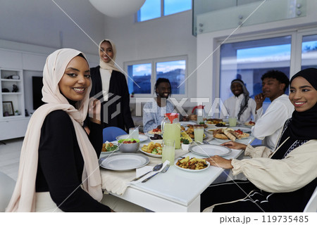 In the sacred month of Ramadan, a Muslim family joyously comes together around a table, eagerly awaiting the communal iftar, engaging in the preparation of a shared meal, and uniting in anticipation In the sacred month of Ramadan, a Muslim family joyously comes together around a table, eagerly awaiting the communal iftar, engaging in the preparation of a shared meal, and uniting in anticipation 119735485
