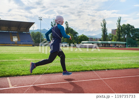 A muslim woman in a burqa sports muslim clothes running on a marathon course and preparing for upcoming competitions 119735733