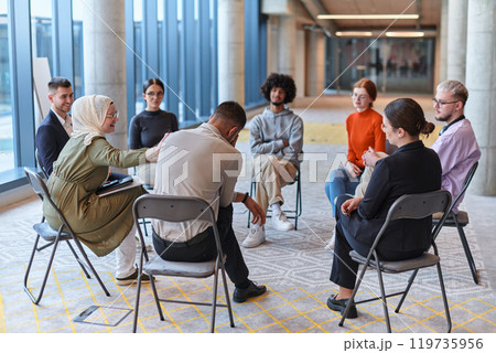 A diverse group of young business entrepreneurs gathered in a circle for a meeting, discussing corporate challenges and innovative solutions within the modern confines of a large corporation A diverse group of young business entrepreneurs gathered in a circle for a meeting, discussing corporate challenges and innovative solutions within the modern confines of a large corporation 119735956