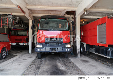 A dedicated firefighter preparing a modern firetruck for deployment to hazardous fire-stricken areas, demonstrating readiness and commitment to emergency response A dedicated firefighter preparing a modern firetruck for deployment to hazardous fire-stricken areas, demonstrating readiness and commitment to emergency response 119736236