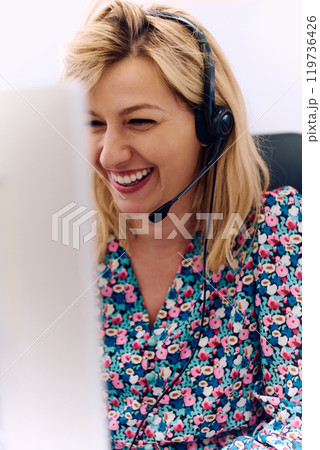 Friendly Call Center Agent Answering Incoming Calls with Headset Providing Remote Customer Service. 119736426