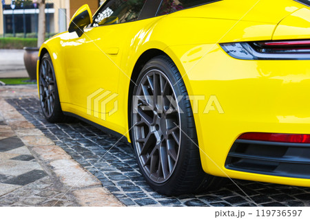 Bright yellow premium car on cobblestones, close-up 119736597
