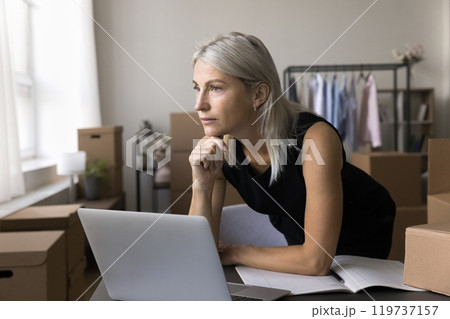 Serious aged businesswoman look away distracted from laptop 119737157