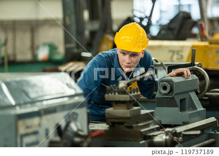 Close up caucasian man engineering workers wear yellow hard hat working machine lathe metal in factory industrial. mechanical operator male worker. Heavy industry concept. 119737189