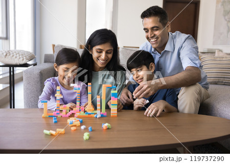 Happy Indian mom and dad helping kids to build towers 119737290