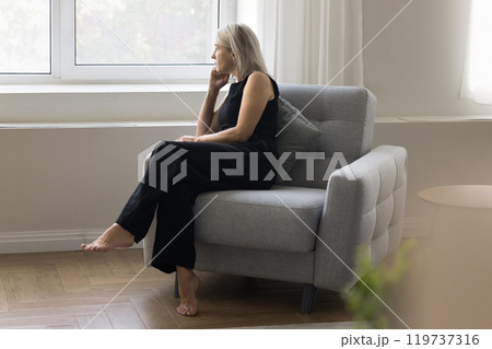 Unhappy mature old lady look at window suffer from loneliness Unhappy mature old lady look at window suffer from loneliness 119737316