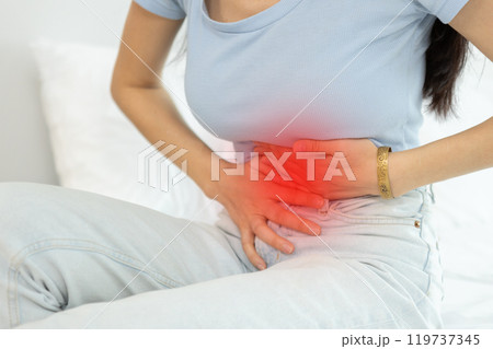 woman sitting on bed stomach ache. Have stomachache, menstrual disorders, food allergies, food poisoning, body aches and pains.  gastritis, diarrhea, enteritis. 119737345