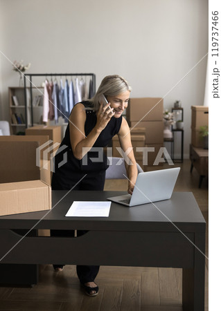 Busy aged female use phone laptop for remote client consultation 119737466