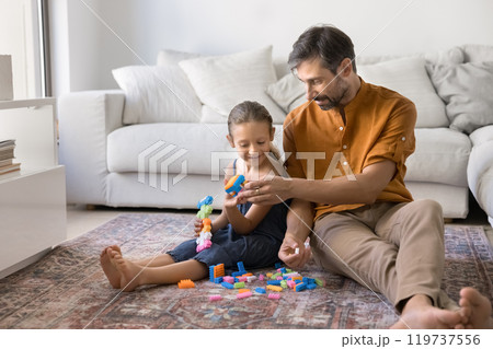 Loving daddy and little girl making toys from construction blocks Loving daddy and little girl making toys from construction blocks 119737556